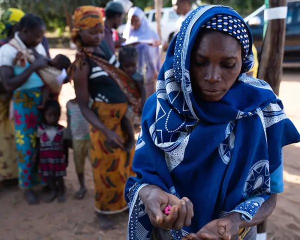 A woman holds pills being distributed as part of the effort to eliminate neglected tropical diseases in Mozambique.