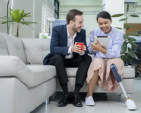 Woman with prosthetic leg talking to man