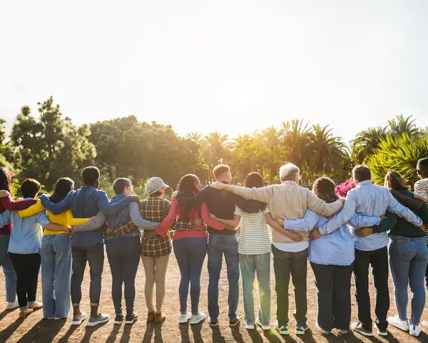 Photo of a group of people in a line with their arms around each other facing away from the camera