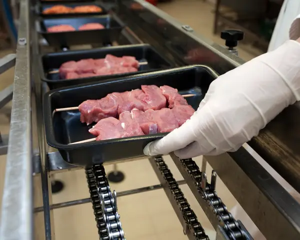 Packaging pork chops on skewers 