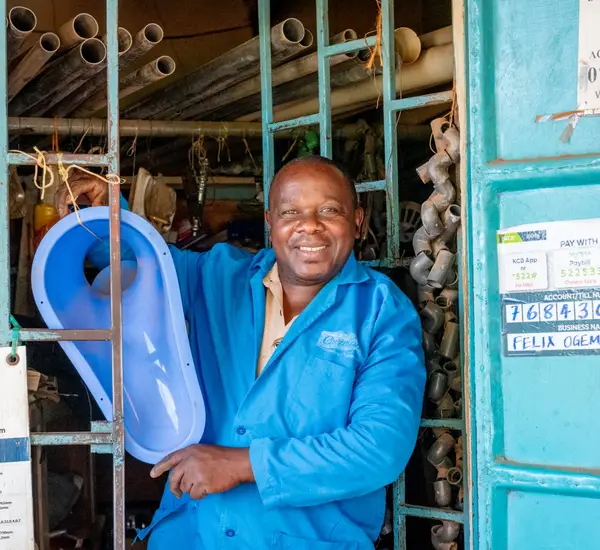 Photo of a Kenyan grocery store owner smiling