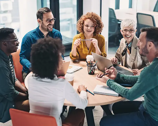 A group of colleagues holds a discussion at a round table.