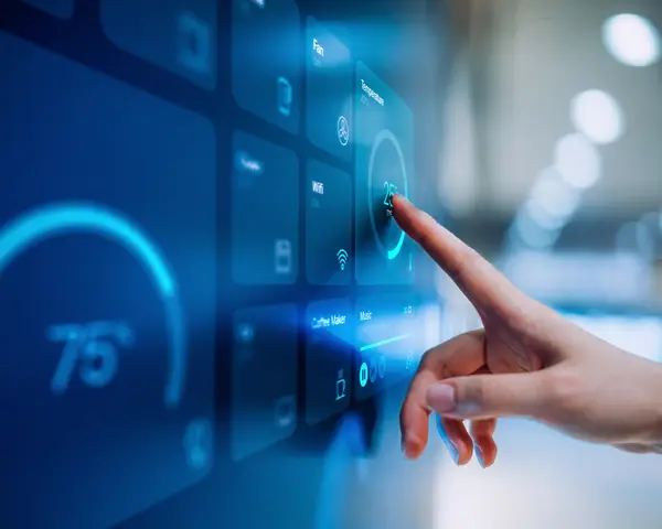 Photo of hand touching a touch screen on a wall. 