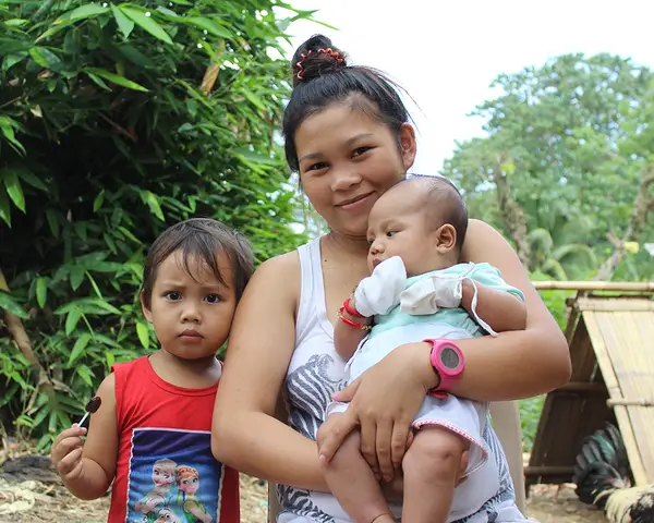 A teen mother and her children in the Philippines.