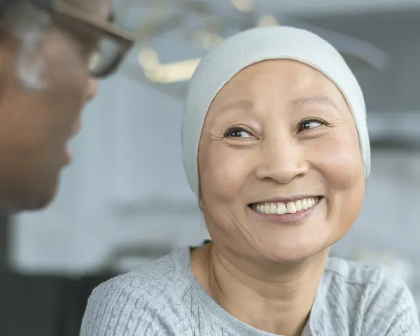 A cancer patient smiles at her doctor.