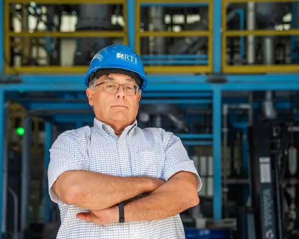 David Dayton wearing an RTI-branded hard hat with his arms crossed