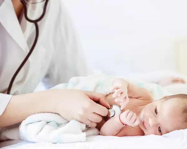 A doctor checks a baby's heartbeat with a stethoscope.