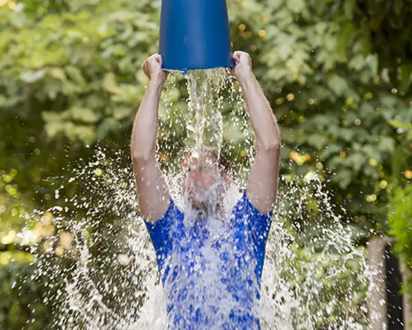 Man pours bucket of ice water over his head as part of ice bucket challenge