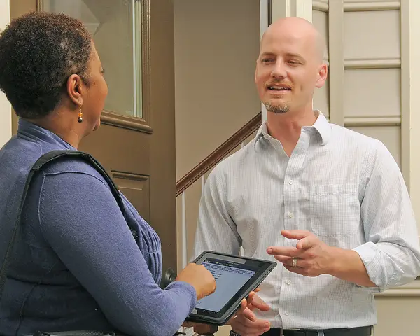 A researcher interviews a man at his home