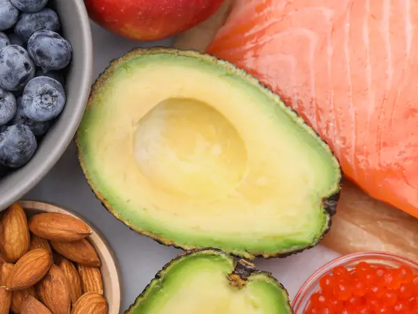 Blueberries, almonds, kiwi slice, avocado halves, salmon