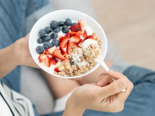 A bowl of yogurt with fruit and granola toppings