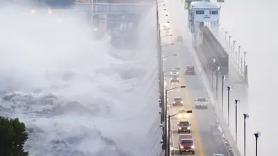 Cars going over bridge that's flooding